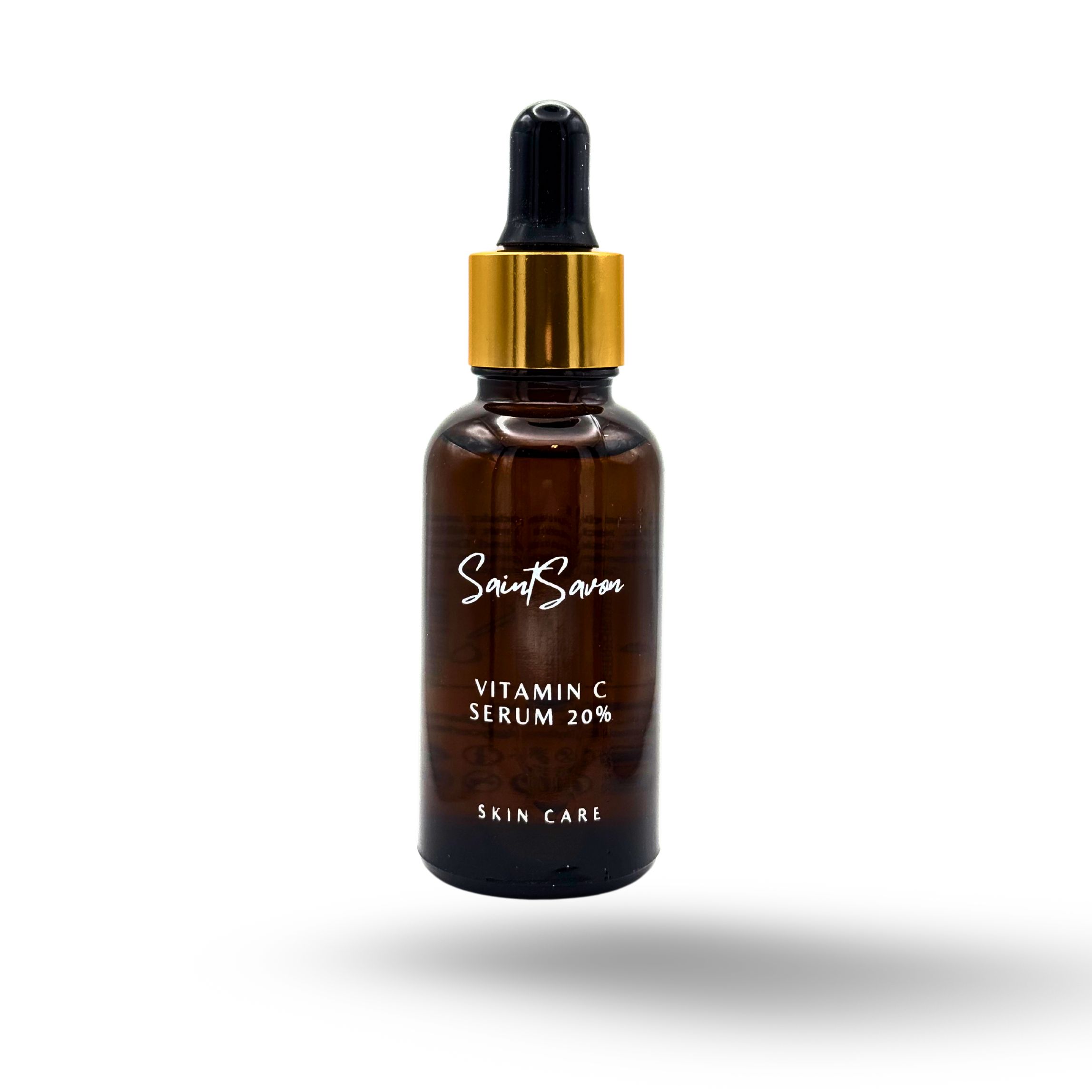 Flacon en verre brun avec bouchon doré et pipette. L'étiquette indique "Saint Savon", "Vitamin C Serum 20%" et "Skin Care".