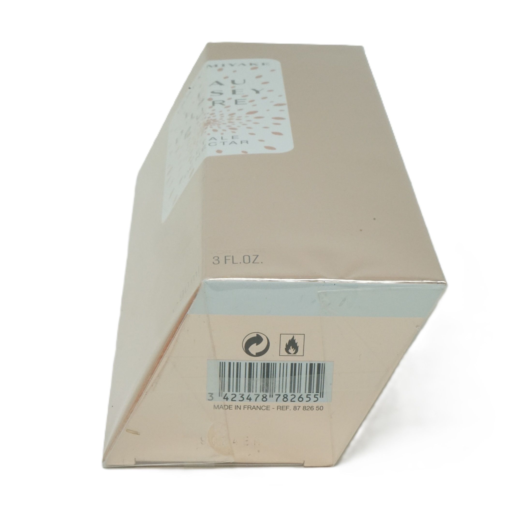 Boîte en carton beige inclinée. Impression avec code-barres, symboles d'avertissement et "3 FL.OZ.".