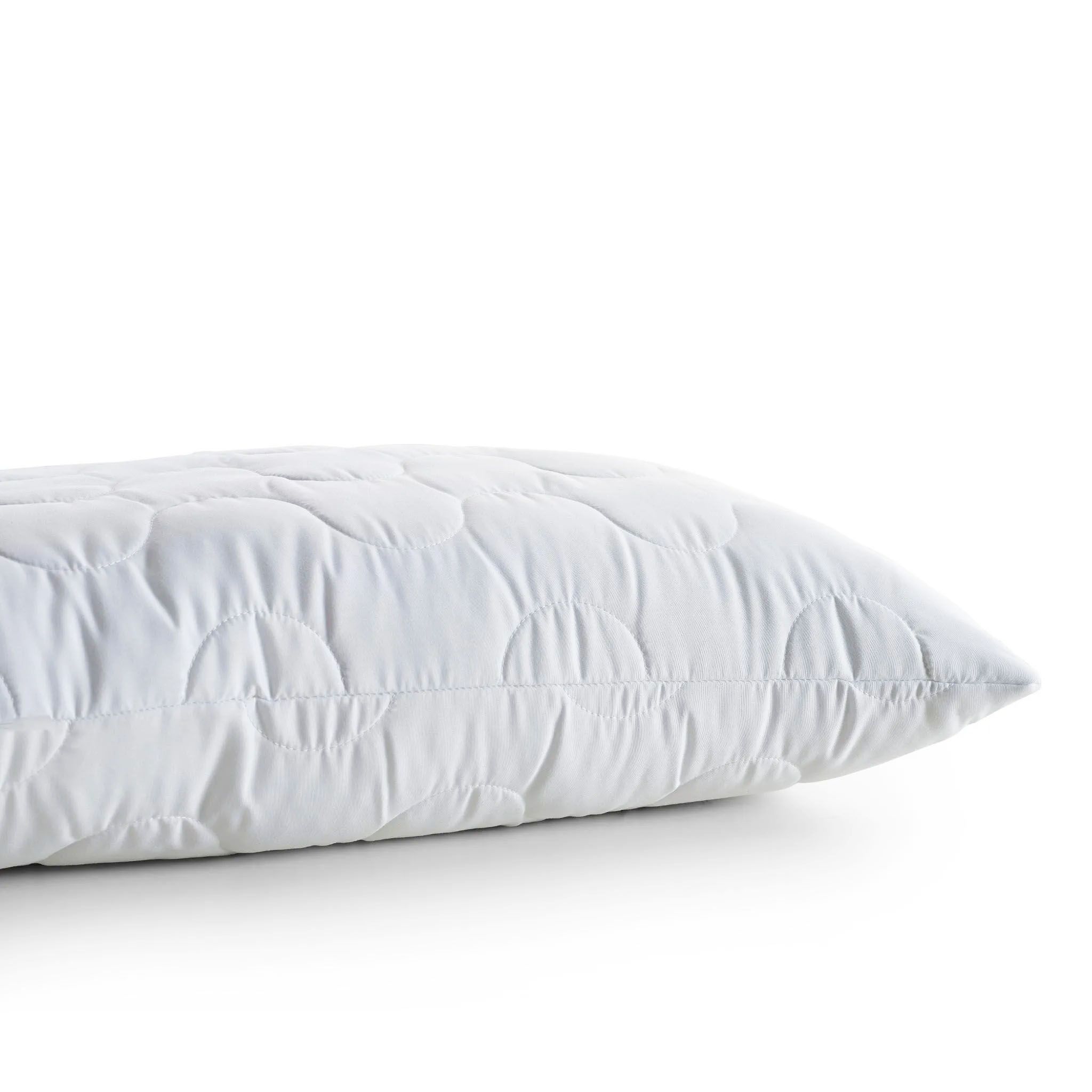 Gros plan d'un oreiller blanc matelassé. Vue d'angle.