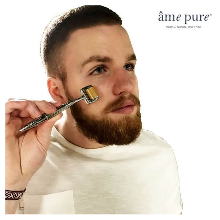 Homme utilisant un dermaroller sur son visage.