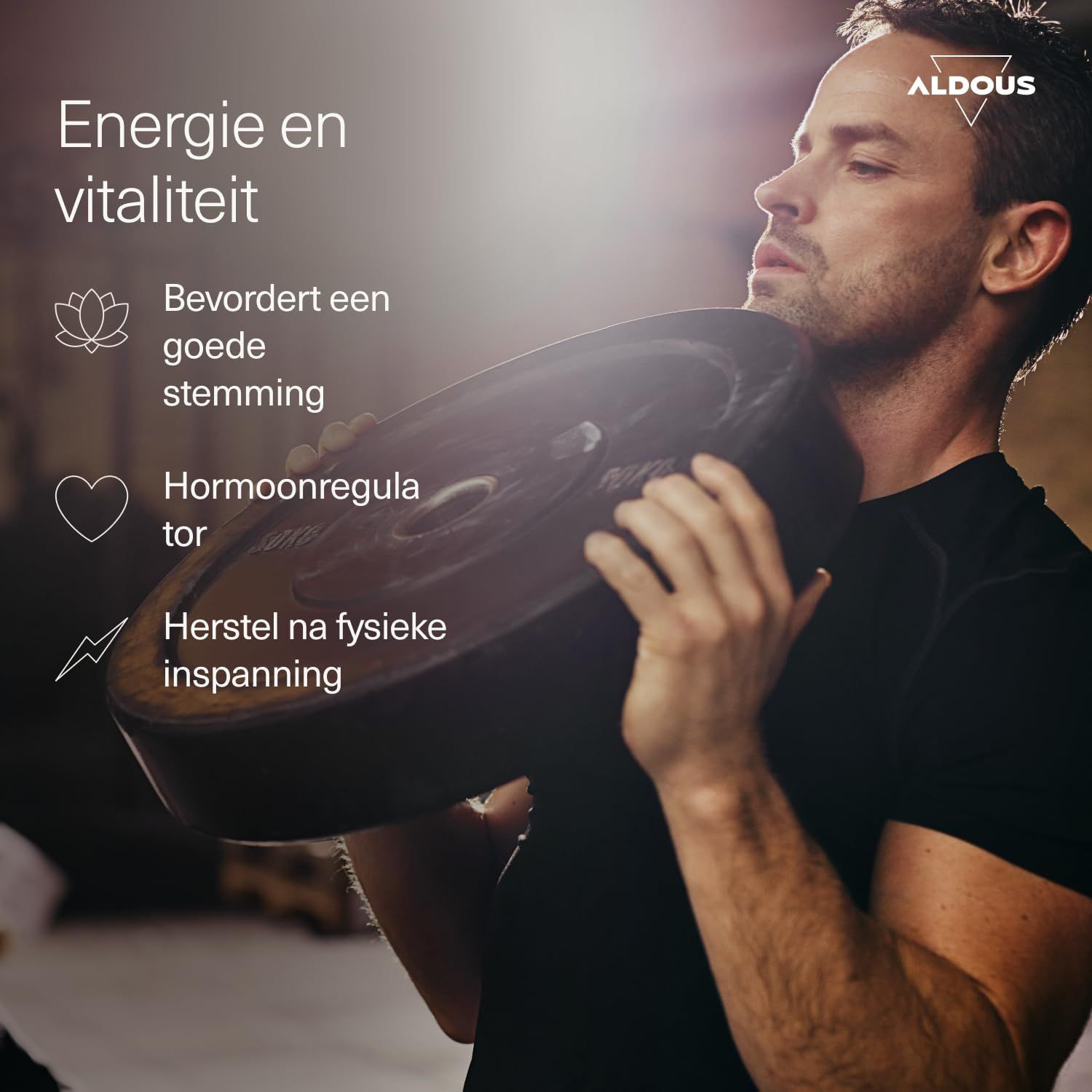Man draagt een ronde, donkere gewichtsschijf op zijn schouder. ALDOUS logo rechtsboven.