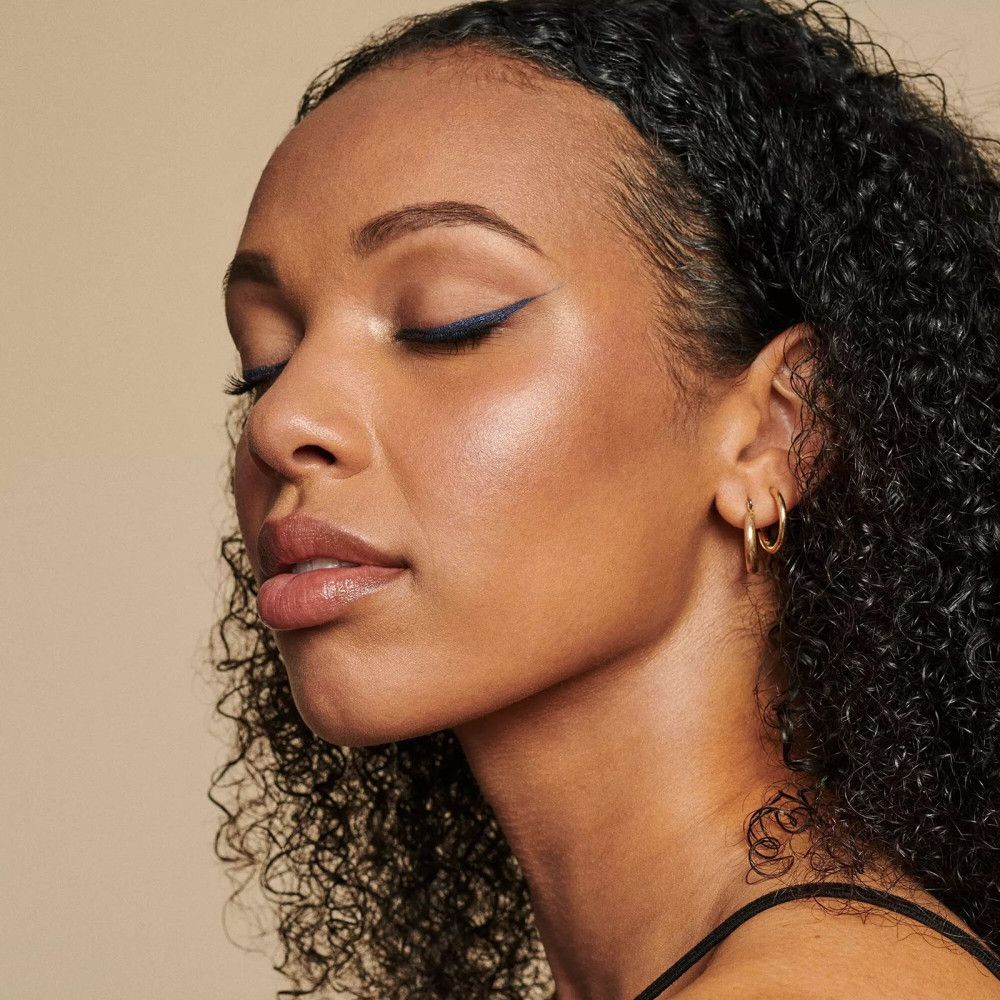 Gros plan sur un visage avec un œil fermé et un trait d'eye-liner bleu.