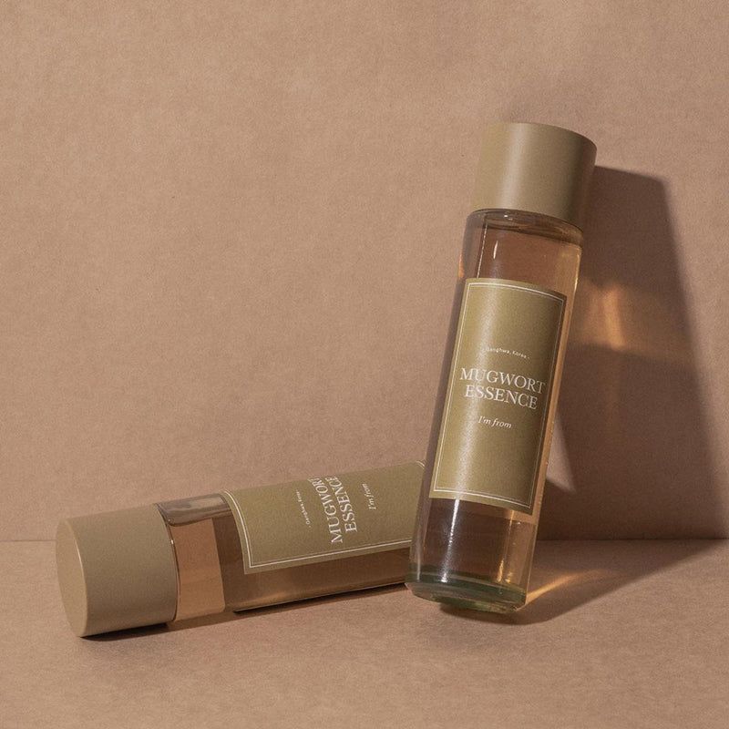 Twee flessen met gouden doppen en etiketten. Opschrift: Mugwort Essence.