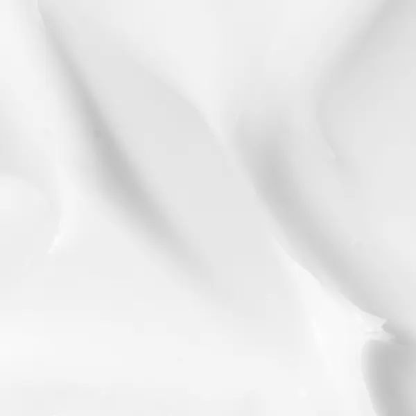 Gros plan sur de la crème blanche. Texture lisse et brillante.