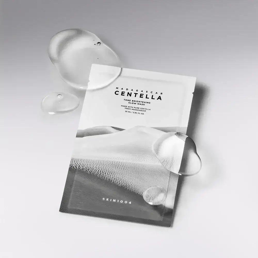 Verpakking van SKIN1004 Glow Mask. Wit zakje met landschapsdruk en productnaam. Duidelijke vloeistofdruppels ernaast.