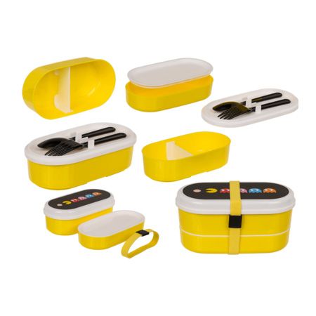 Gele lunchbox met twee compartimenten, wit deksel en Pac-Man-motief. Inclusief bestek. Gele elastische band sluiting.