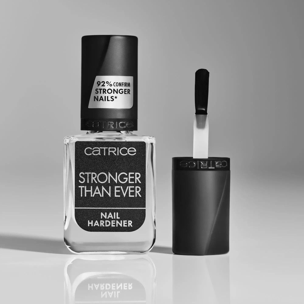 Zwart-wit foto van een nagelverharder fles met open dop en borstel. Opschrift: Catrice, Stronger Than Ever, Nail Hardener. 92%.