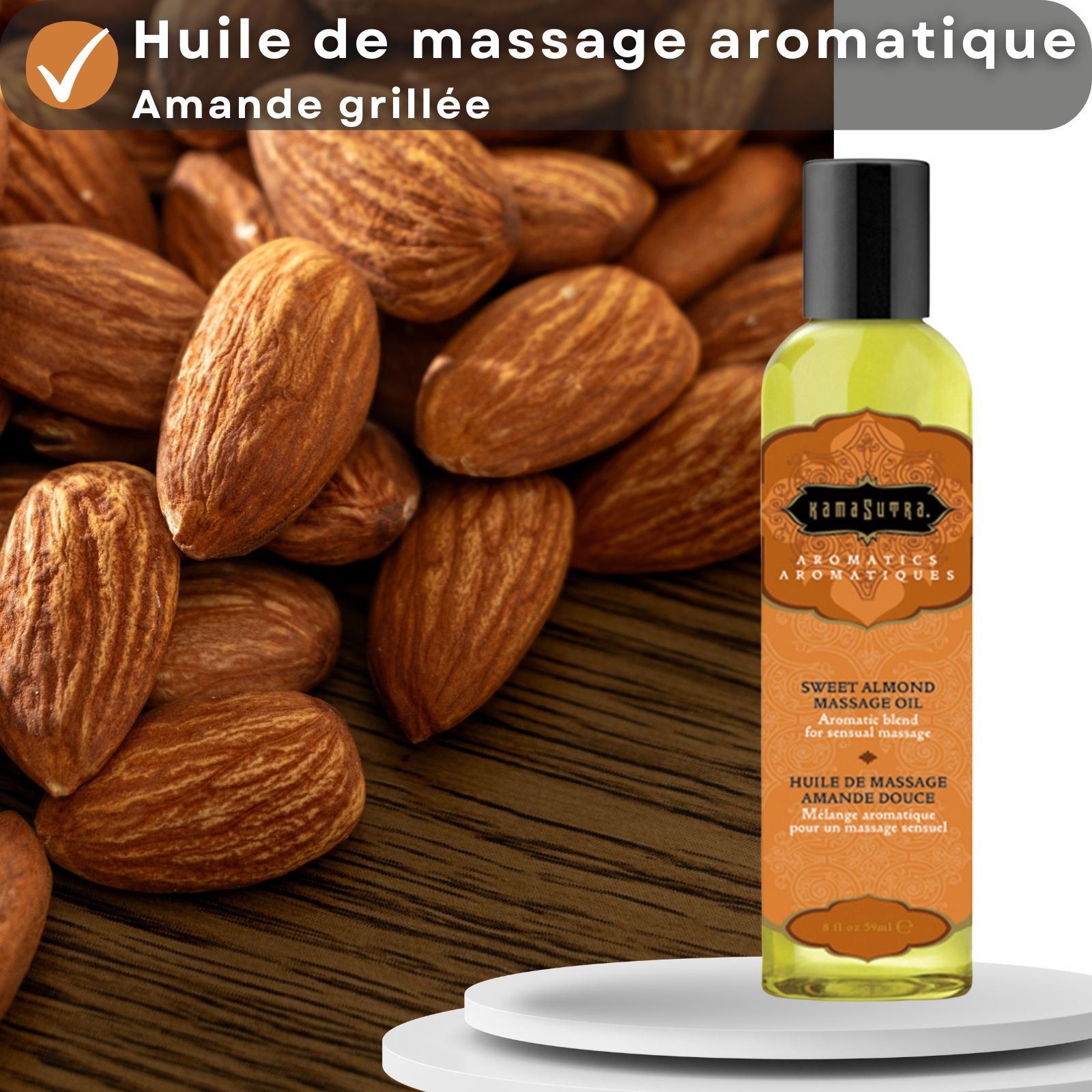 Huile de massage Kamasutra, arôme amande grillée. Flacon à côté d'amandes sur fond bois. Informations produit.