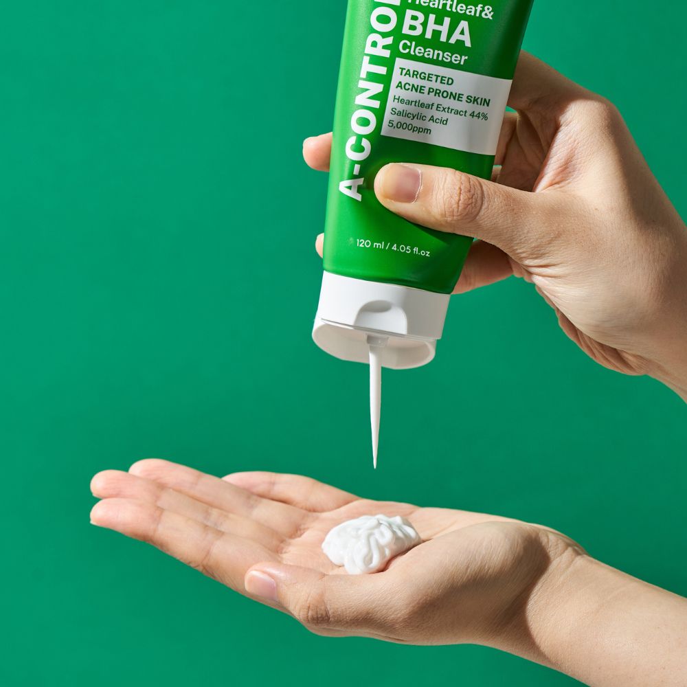 Groene tube, product wordt in hand gedrukt. Witte crème wordt in handpalm gedaan. Tekst: A-Control, Heartleaf & BHA Cleanser.