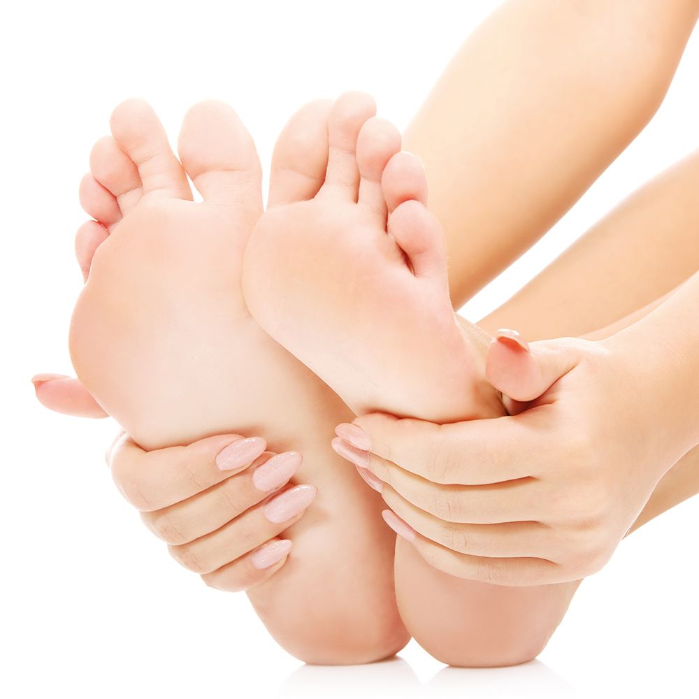 Gros plan sur des pieds tenus par des mains. Contexte de soins de la peau.