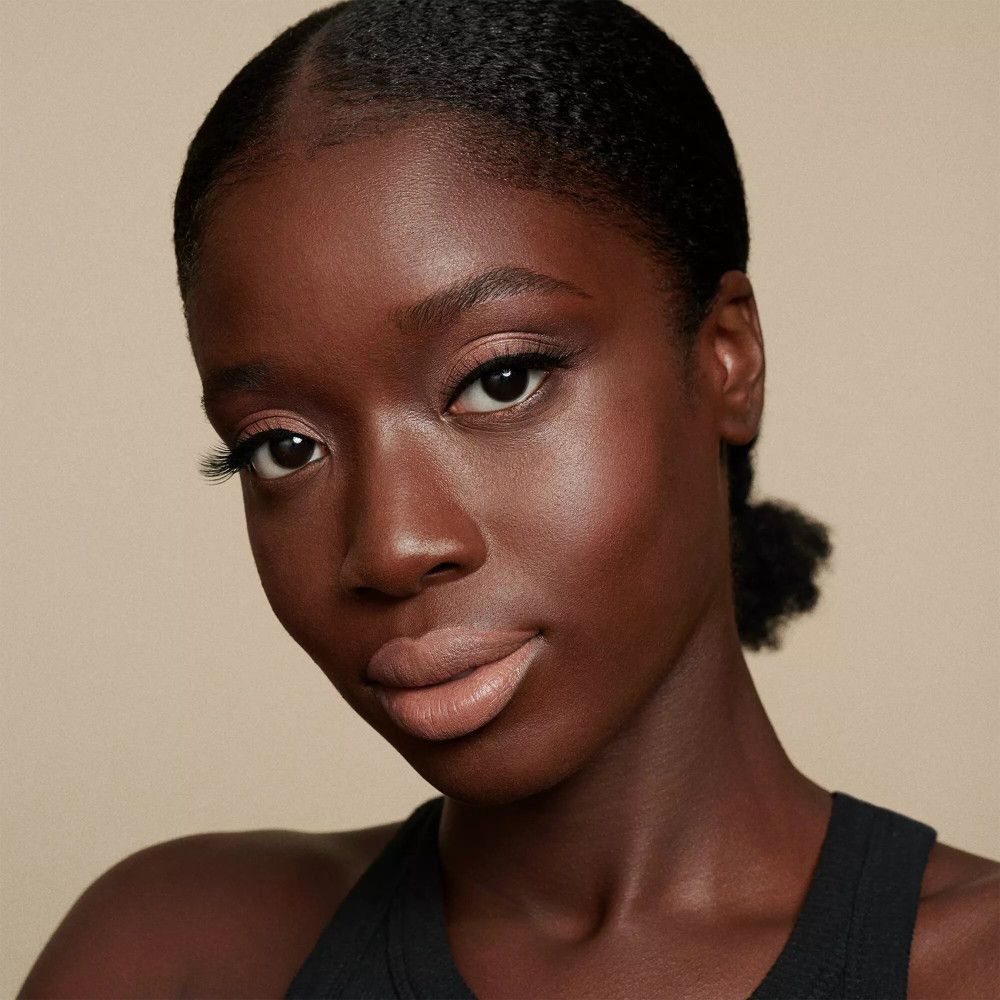 Portret van een vrouw met lippenstift. Huidskleur: bruin. Kleur lippen: bruin.