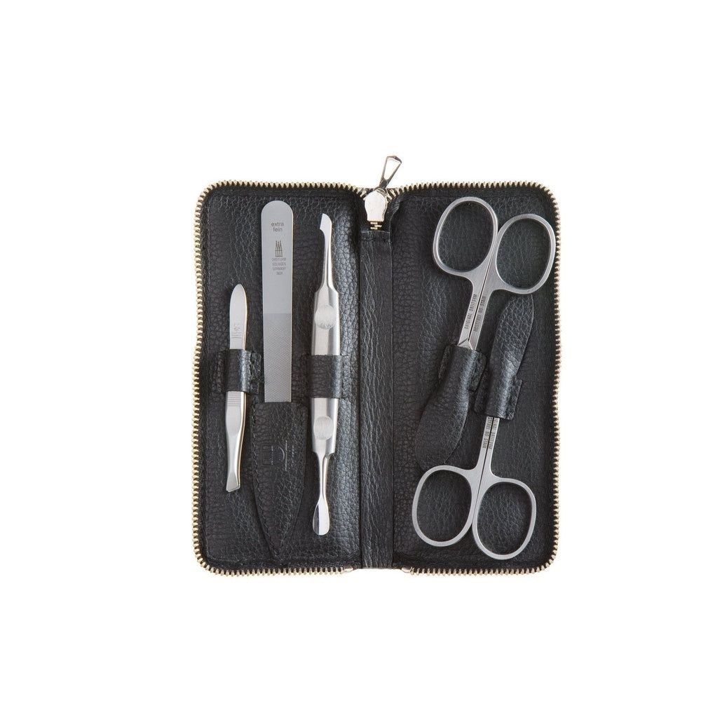 Set de manucure dans un étui en cuir noir avec pince à épiler, repousse-cuticules, lime à ongles et deux ciseaux.
