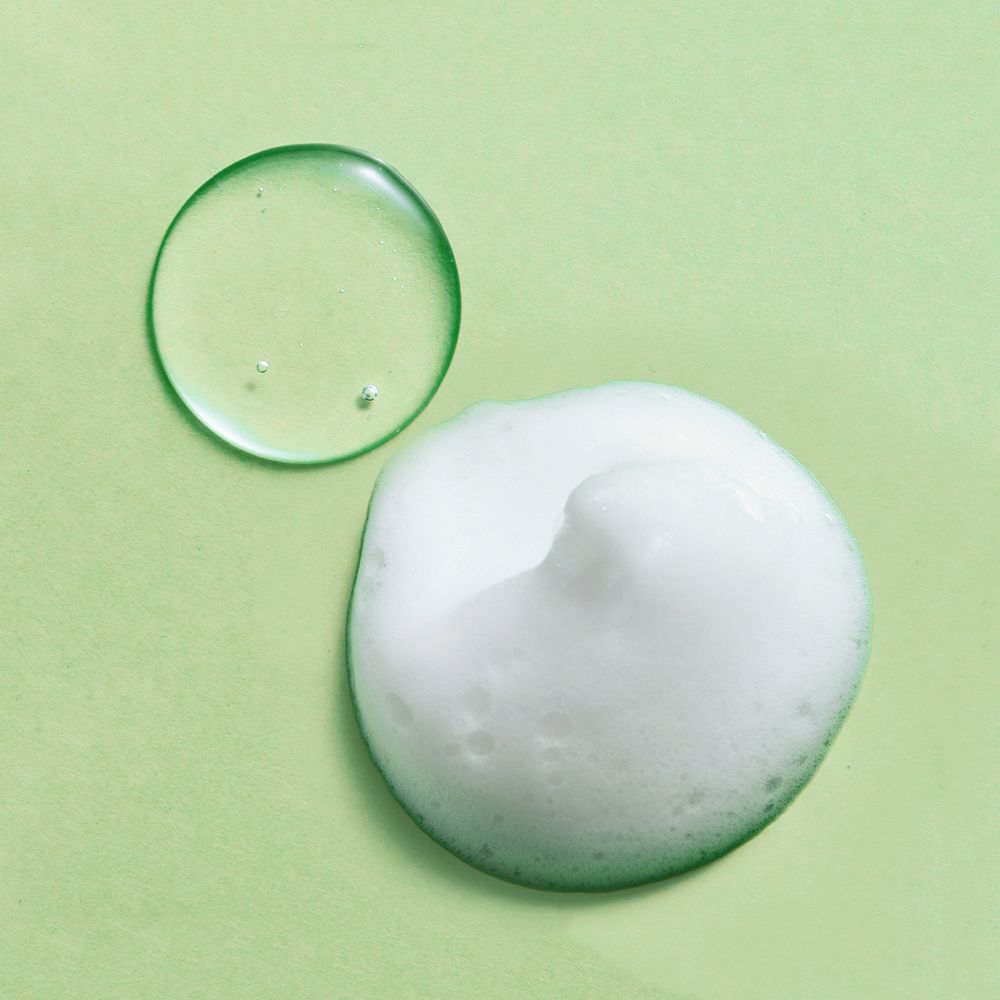 Deux cercles sur fond vert. En haut: liquide clair. En bas: mousse. Pas de nom de produit.