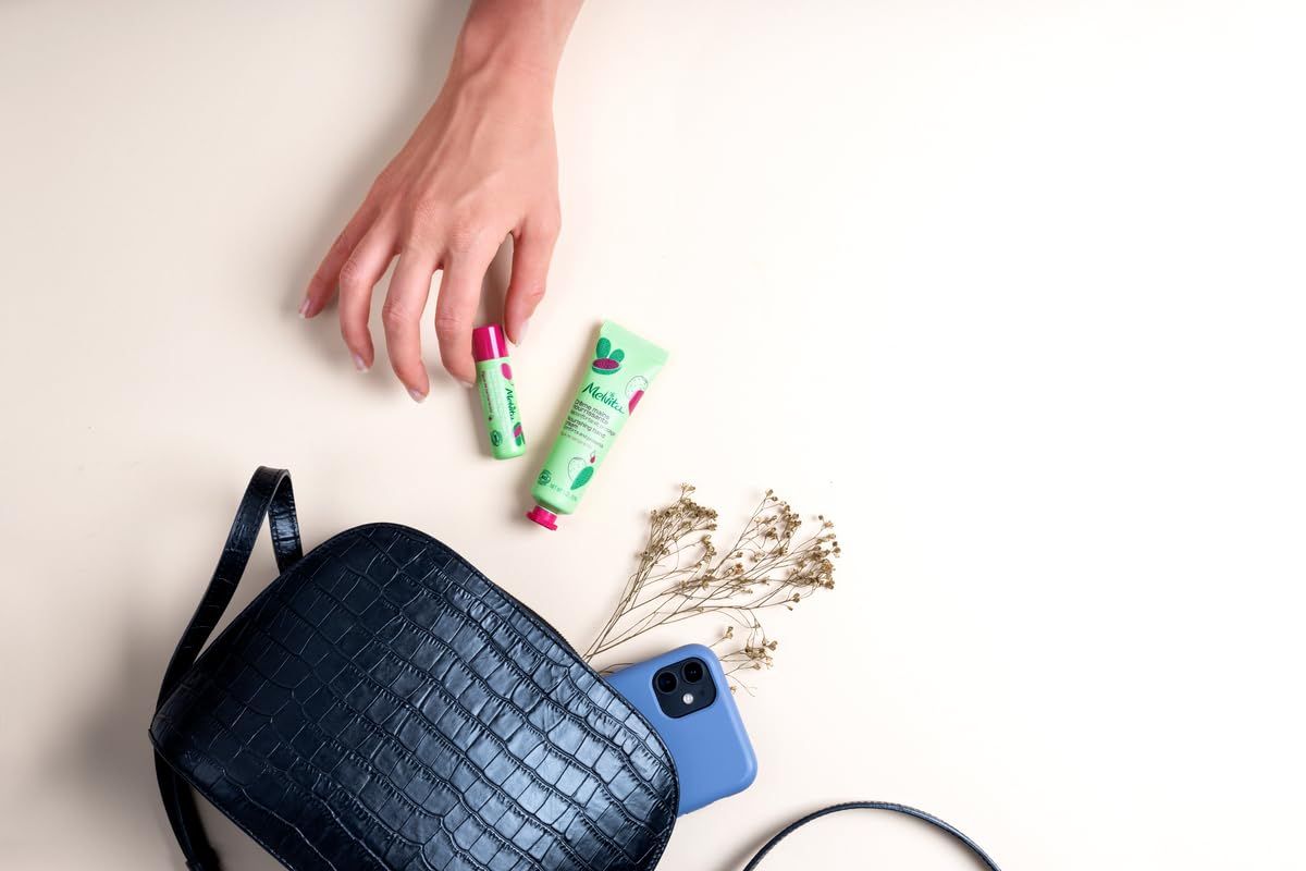 Main avec produits cosmétiques. Sac à main, baume à lèvres, crème, téléphone. Design vert et rose.