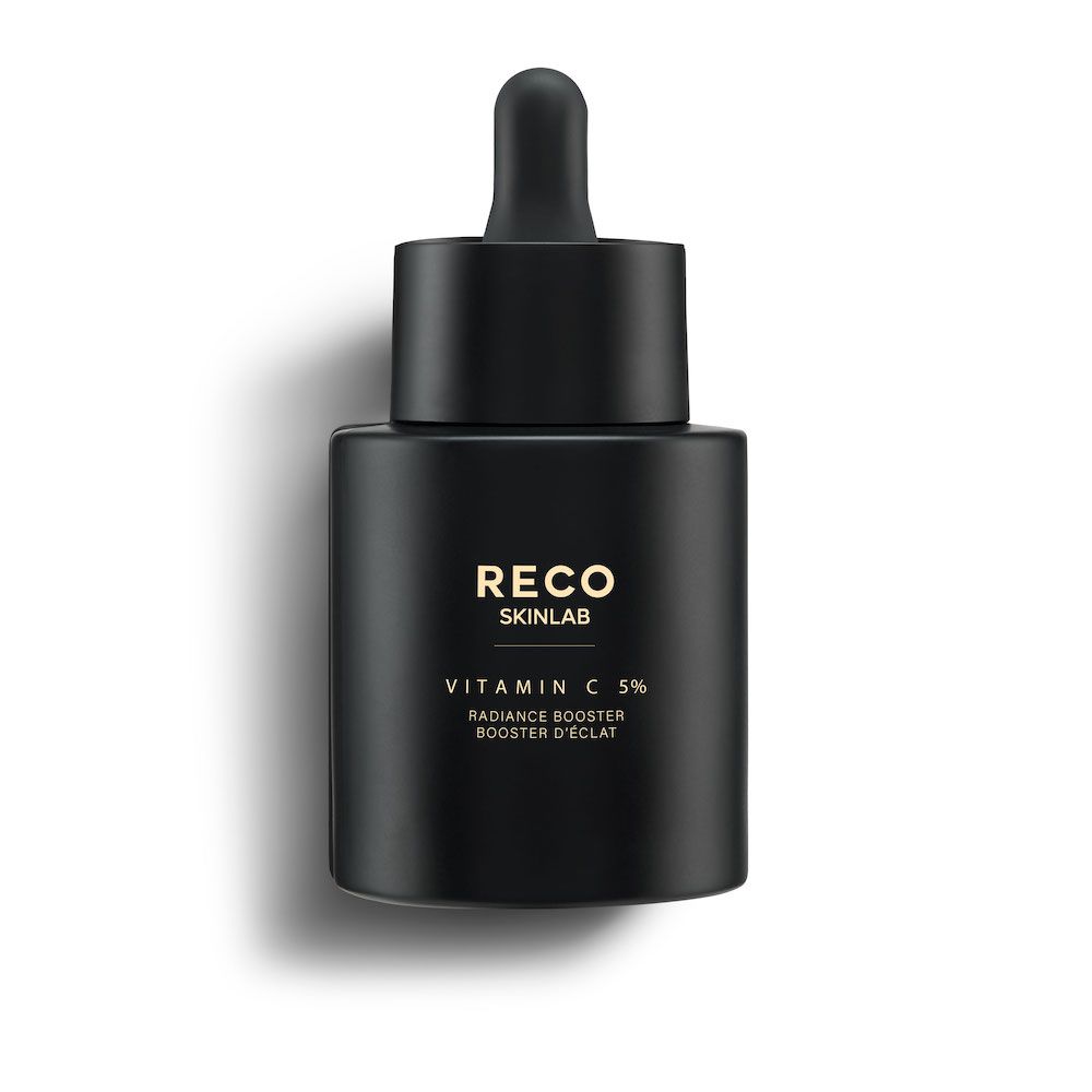 Zwarte flacon met druppelaar. Opschrift: RECO SKINLAB. Product: Vitamine C 5% Radiance Booster. Zwarte dop.