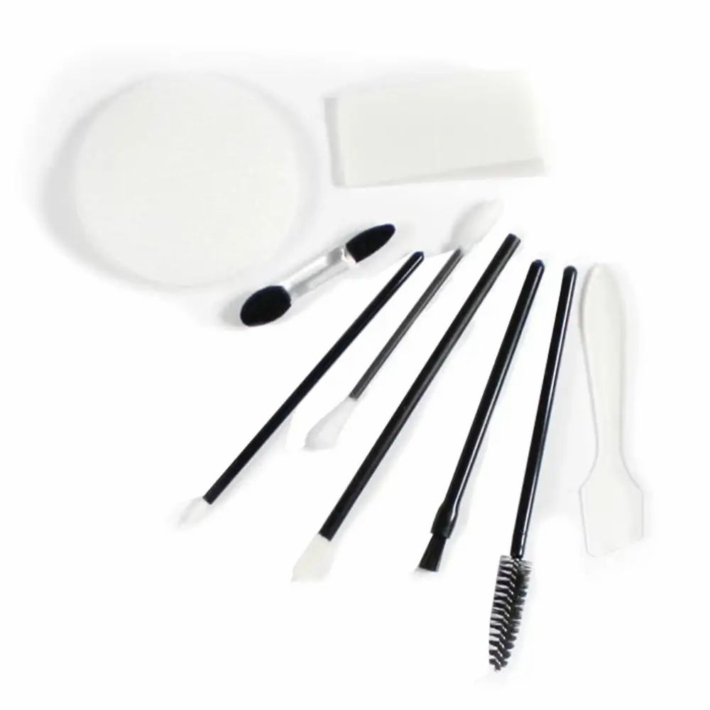 Diverse make-up applicators. Ronde sponzen, stokjes, penselen en spatels. Zwarte en witte handvatten.
