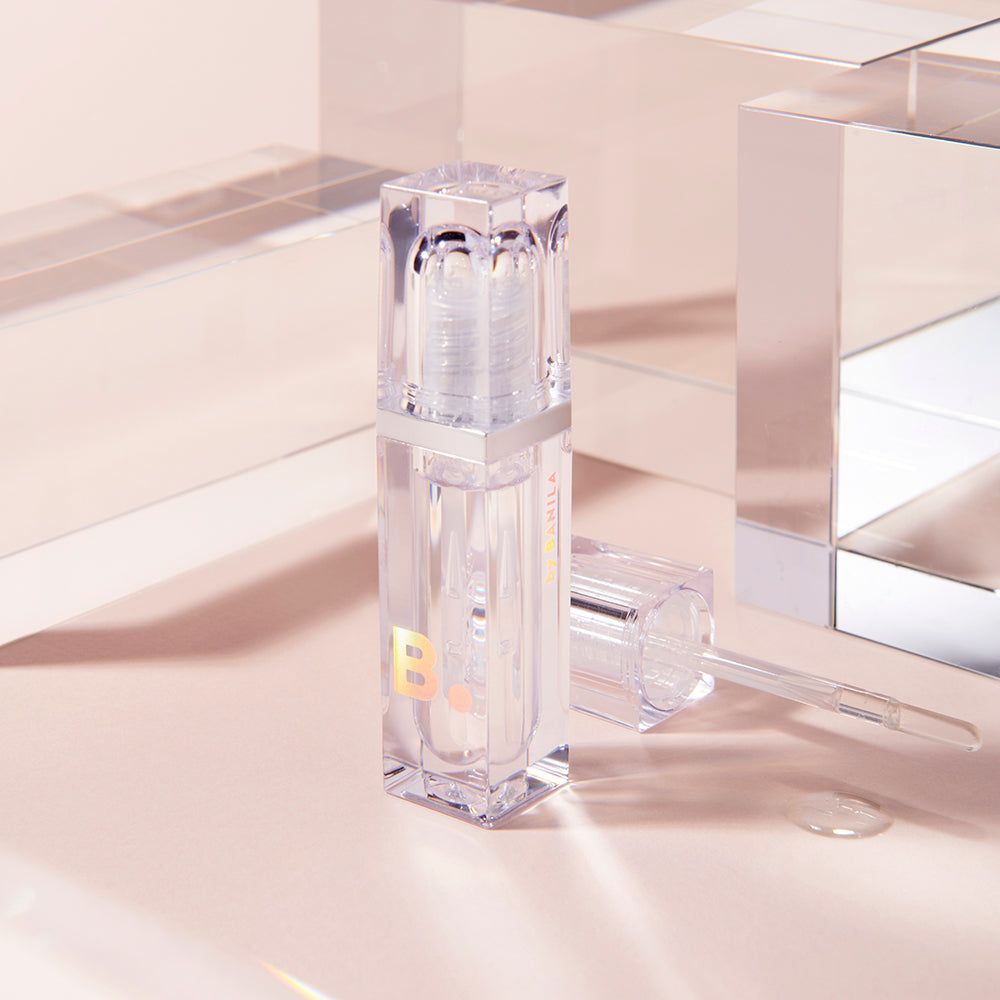 Flacon transparent avec bande argentée et applicateur. Contient un liquide clair. Une lettre 'B' est visible sur le flacon.