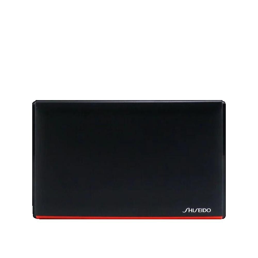 Poudre compacte noire avec bande rouge et logo Shiseido. Forme rectangulaire.
