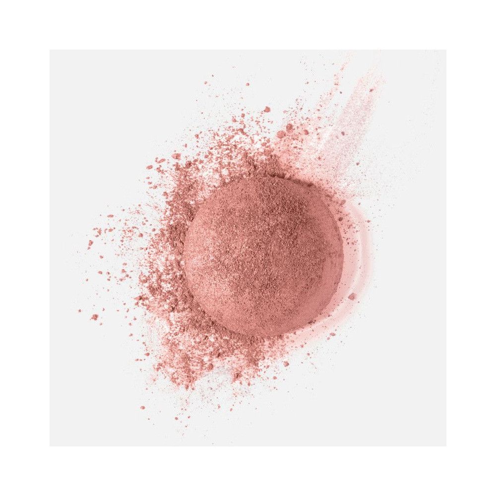 Poudre rose en forme de cercle, avec des particules. Fond blanc.