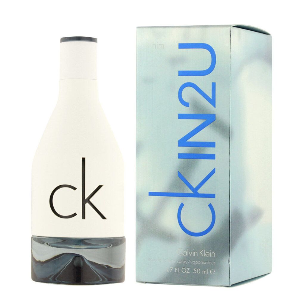 Flacon de parfum blanc et boîte. Inscription : ck IN2U, Calvin Klein. Flacon avec base argentée et bouchon noir.