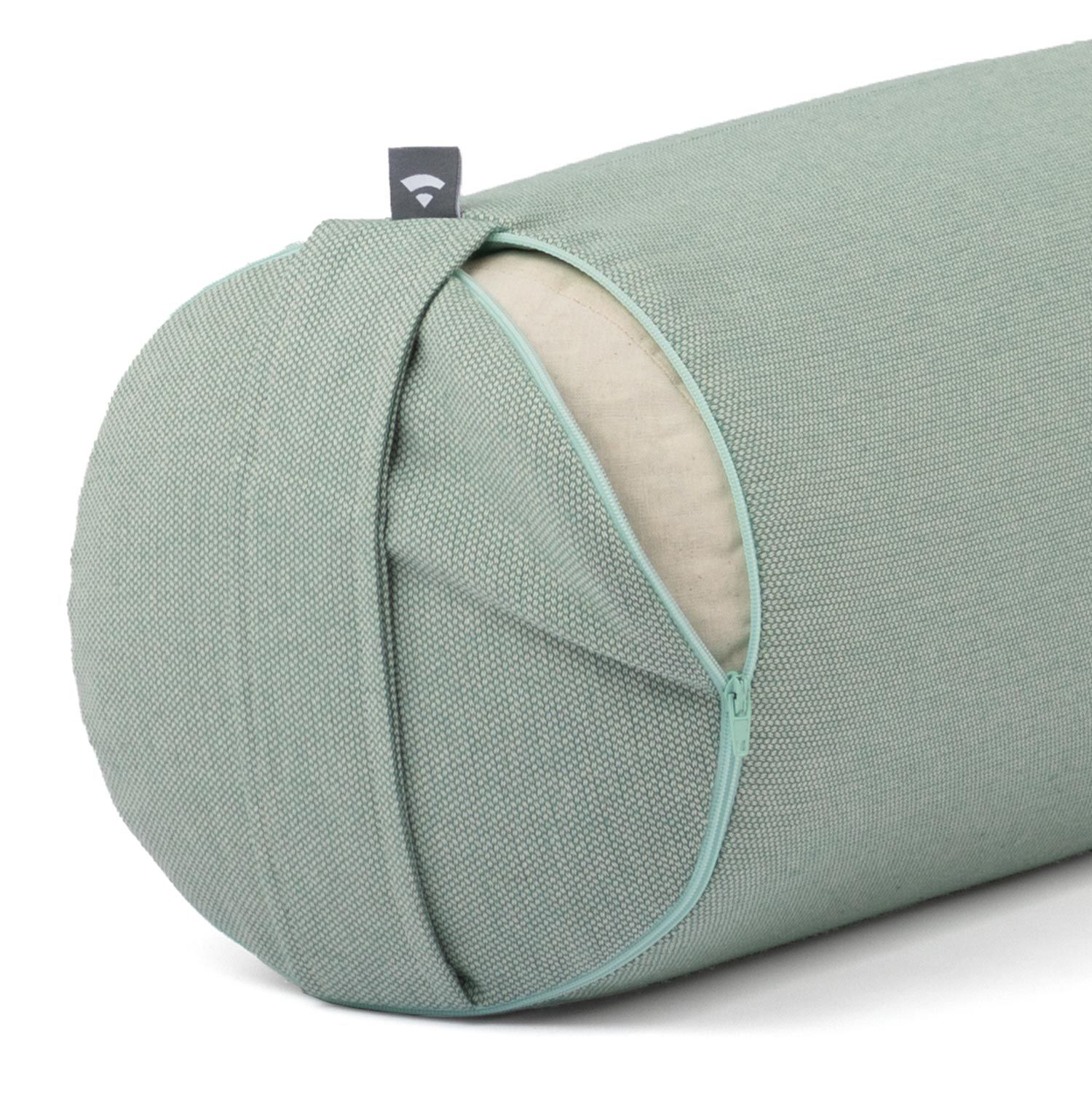 Close-up van een groene yoga bolster. Stoffen hoes met rits en lichtgroene naad. Logo label.