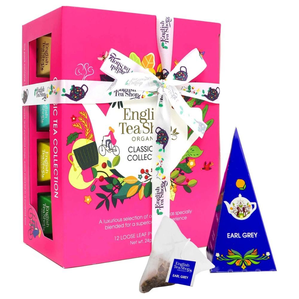 Roze geschenkdoos met lint, gevuld met theezakjes. Een theezakje en een blauwe piramidebox ernaast. Opschrift: English Tea Shop.