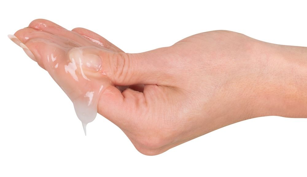 Main avec du gel. Le gel coule de la main. Le gel est transparent.