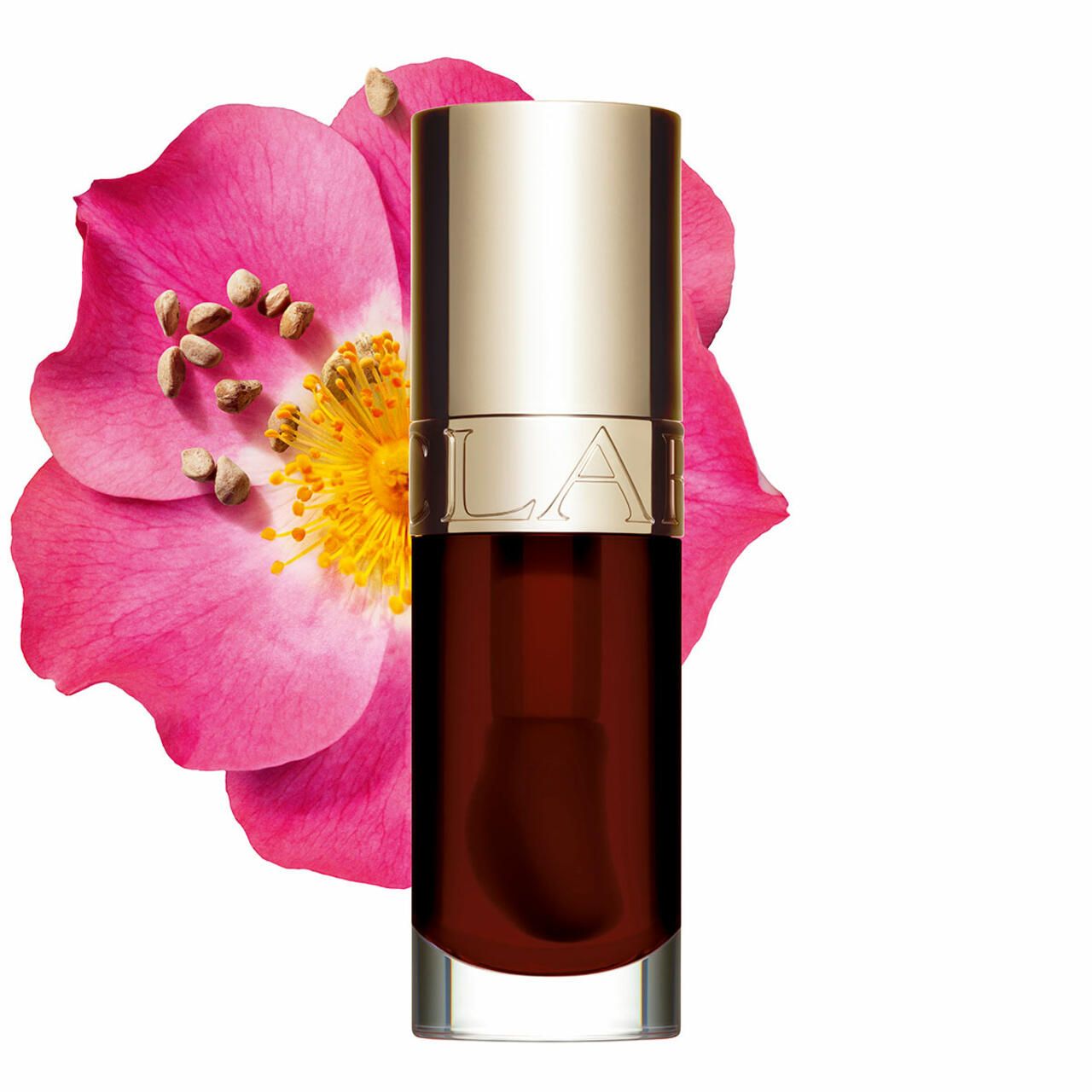 Clarins Lip Comfort Oil donkerrood naast een roze bloem.