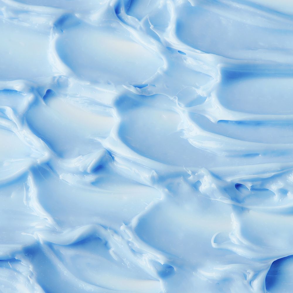 Produit de soin pour la peau bleu et crémeux, gros plan.