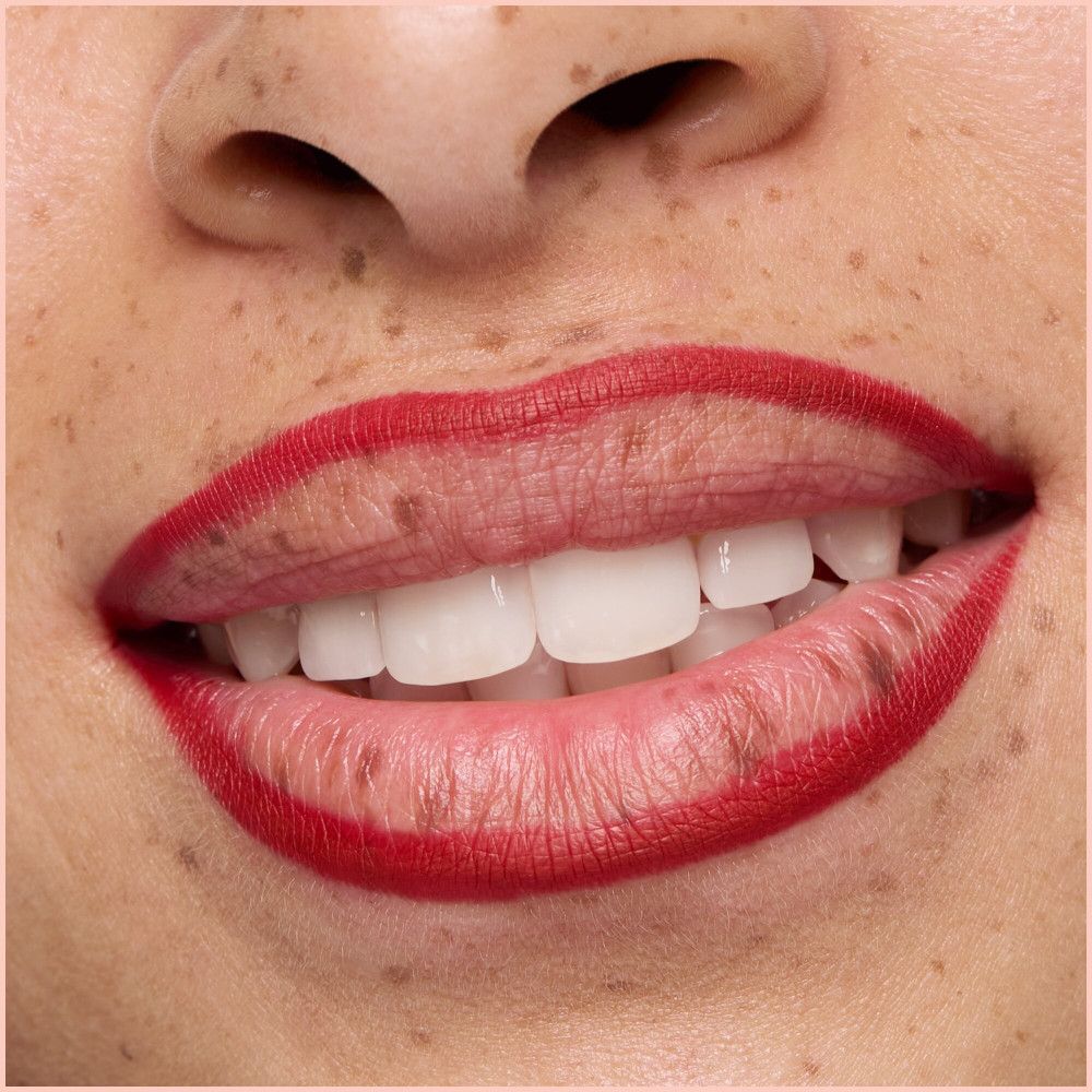Close-up van lippen omrand met rode lippenstift. Witte tanden.