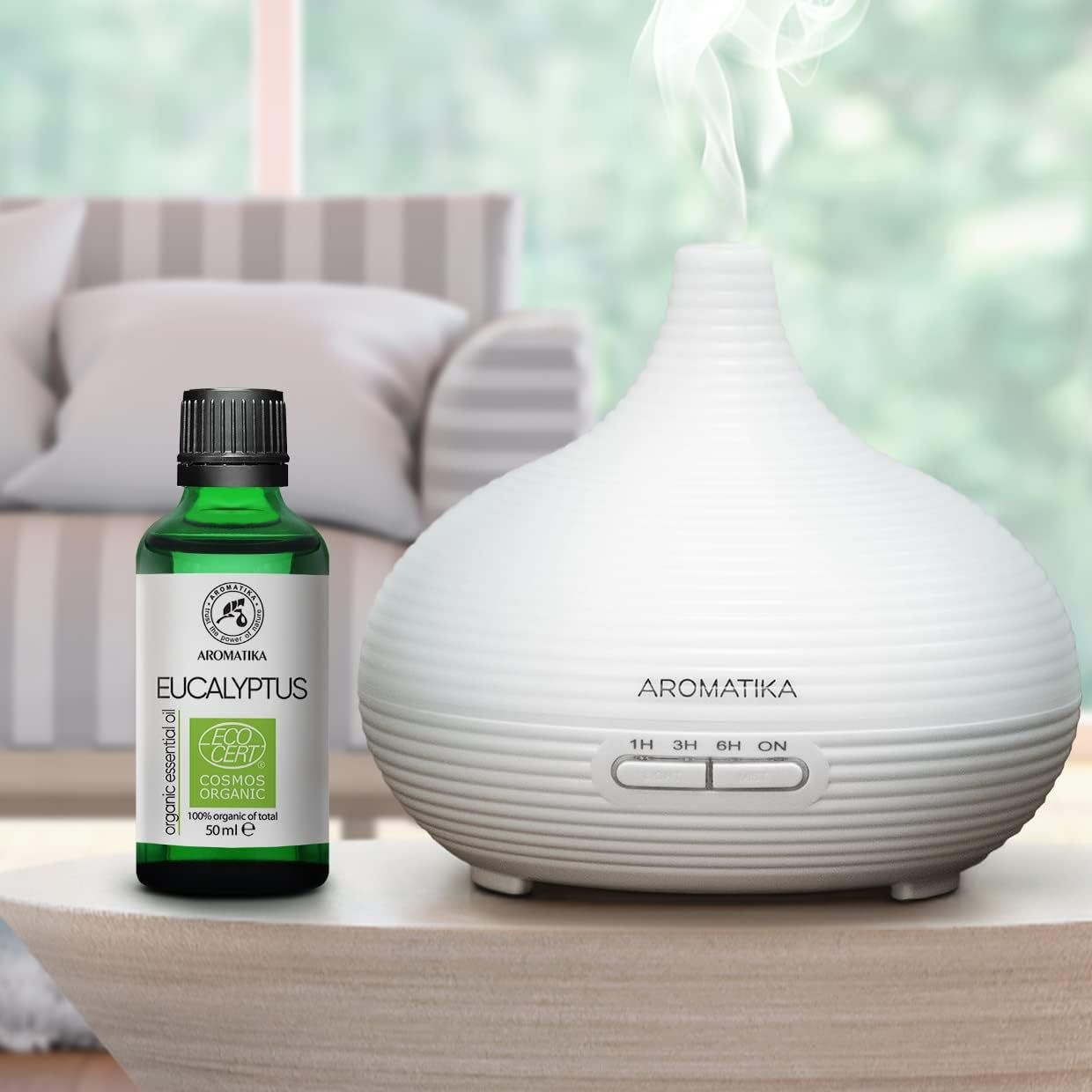 AROMATIKA Eucalyptusolie fles naast een witte aroma diffuser.