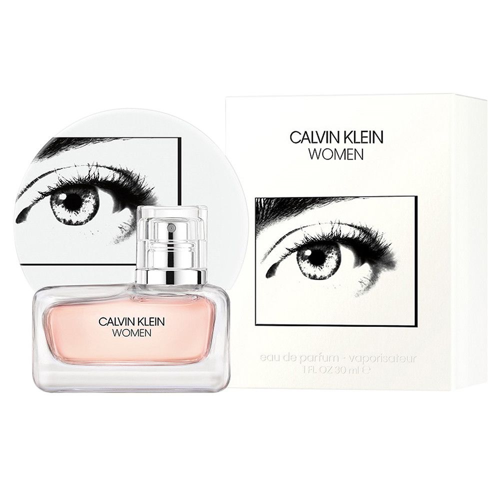 Flacon et emballage. Inscription: CALVIN KLEIN WOMEN. Emballage blanc, graphique d'œil. Flacon avec liquide rose.
