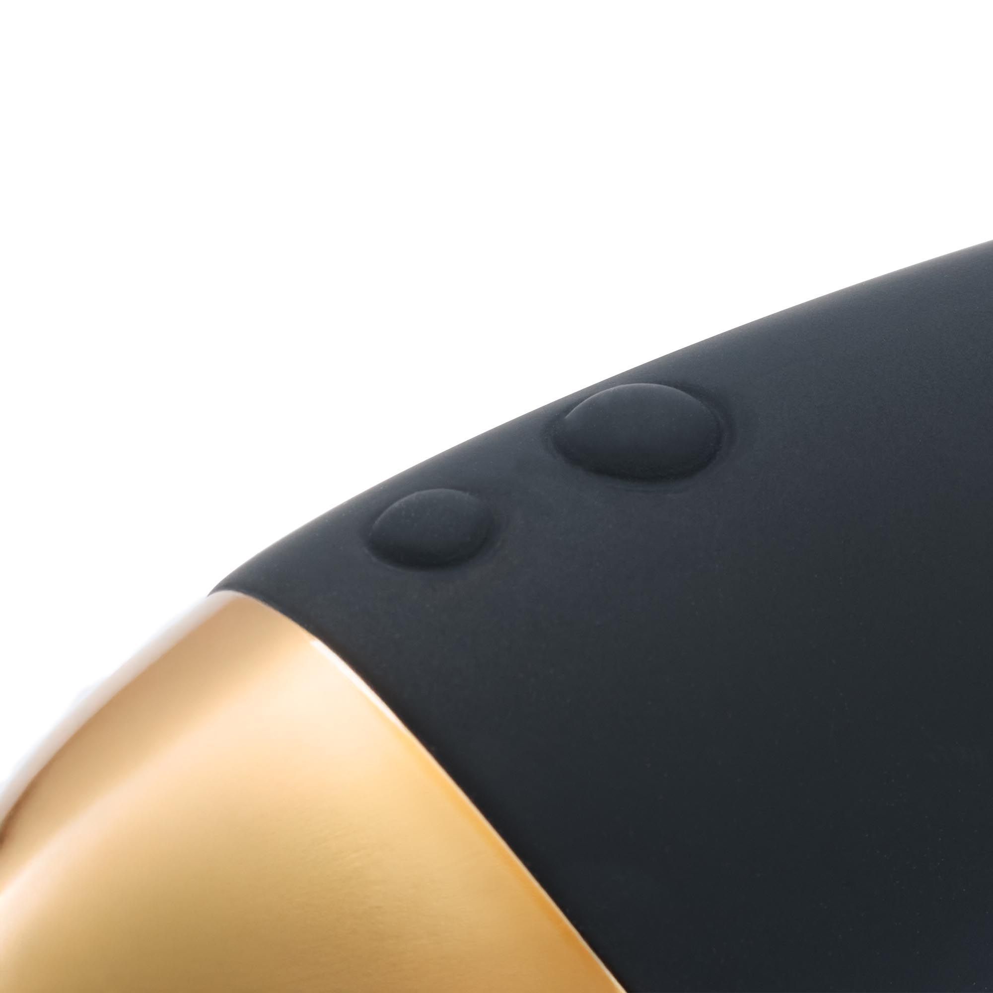 Close-up van de massage wand. Twee knoppen zijn zichtbaar. De wand heeft een gouden basis.
