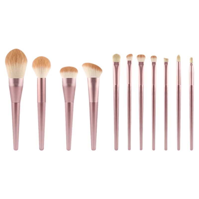 Make-up kwastenset. Roze handvatten, lichte borstelharen. Verschillende vormen en maten. Op witte achtergrond.