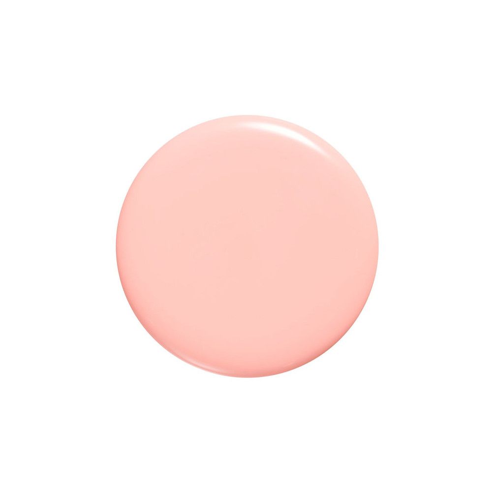 Een ronde druppel lichtroze nagellak op een witte achtergrond.