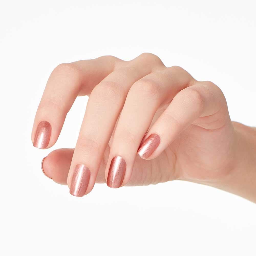 Hand met gelakte nagels. Gouden nagellak op vijf vingernagels.