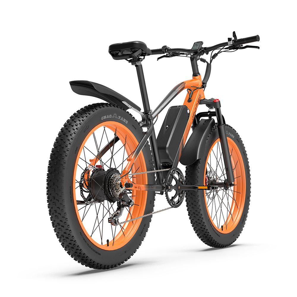Elektrische mountainbike met oranje velgen en banden. Zwart frame, spatborden en zadel. Accu op het frame.