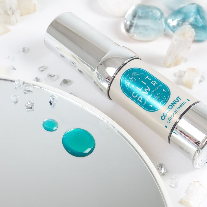 Cilindrische fles met tekst CLIT PWR Coconut. Op een spiegel met druppels. Decoratieve elementen.