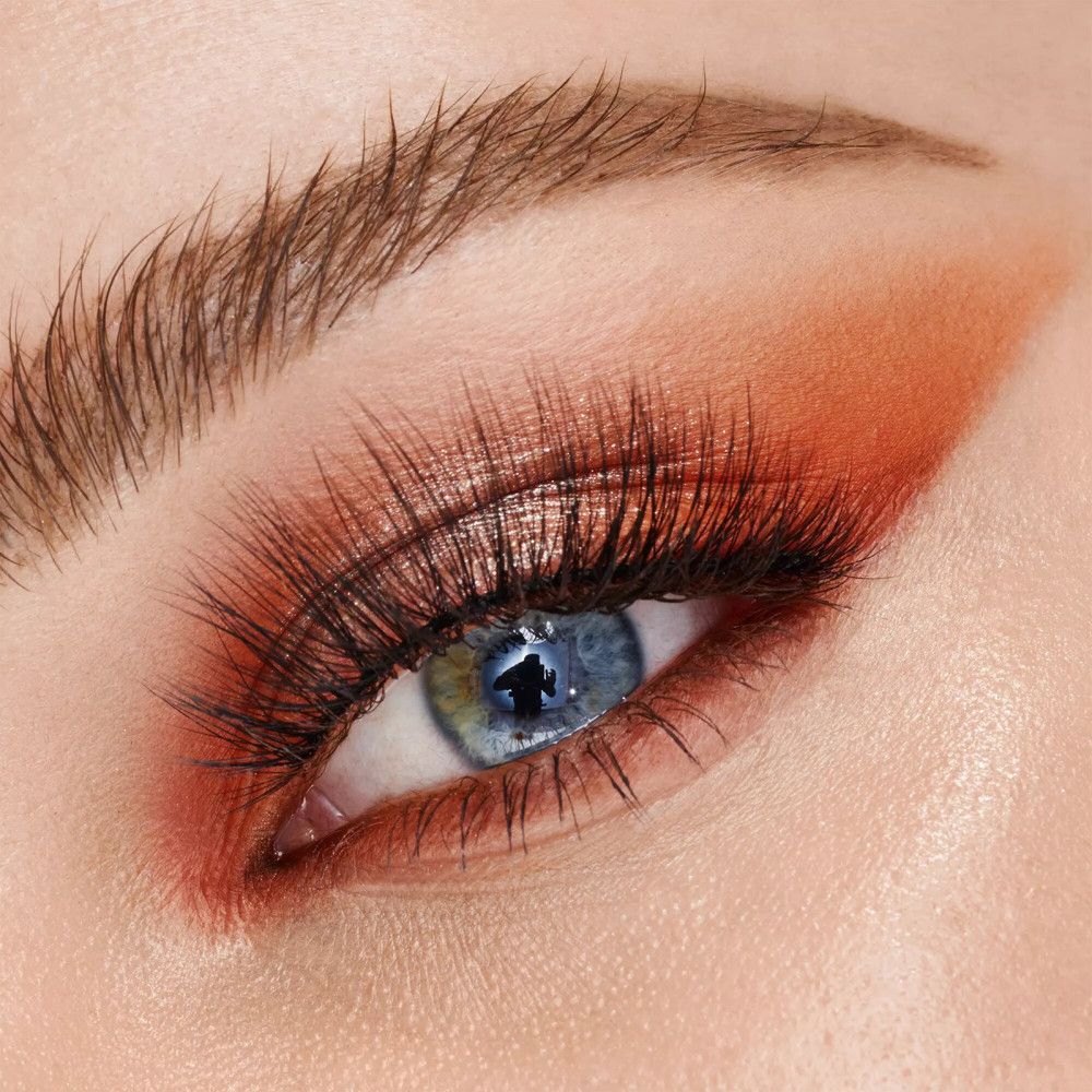 Close-up van een oog met oogschaduw en valse wimpers. Oranje oogschaduw.