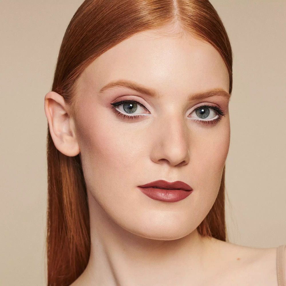 Portret van een vrouw met make-up. Donkerrode lippen, eyeliner, oogschaduw.