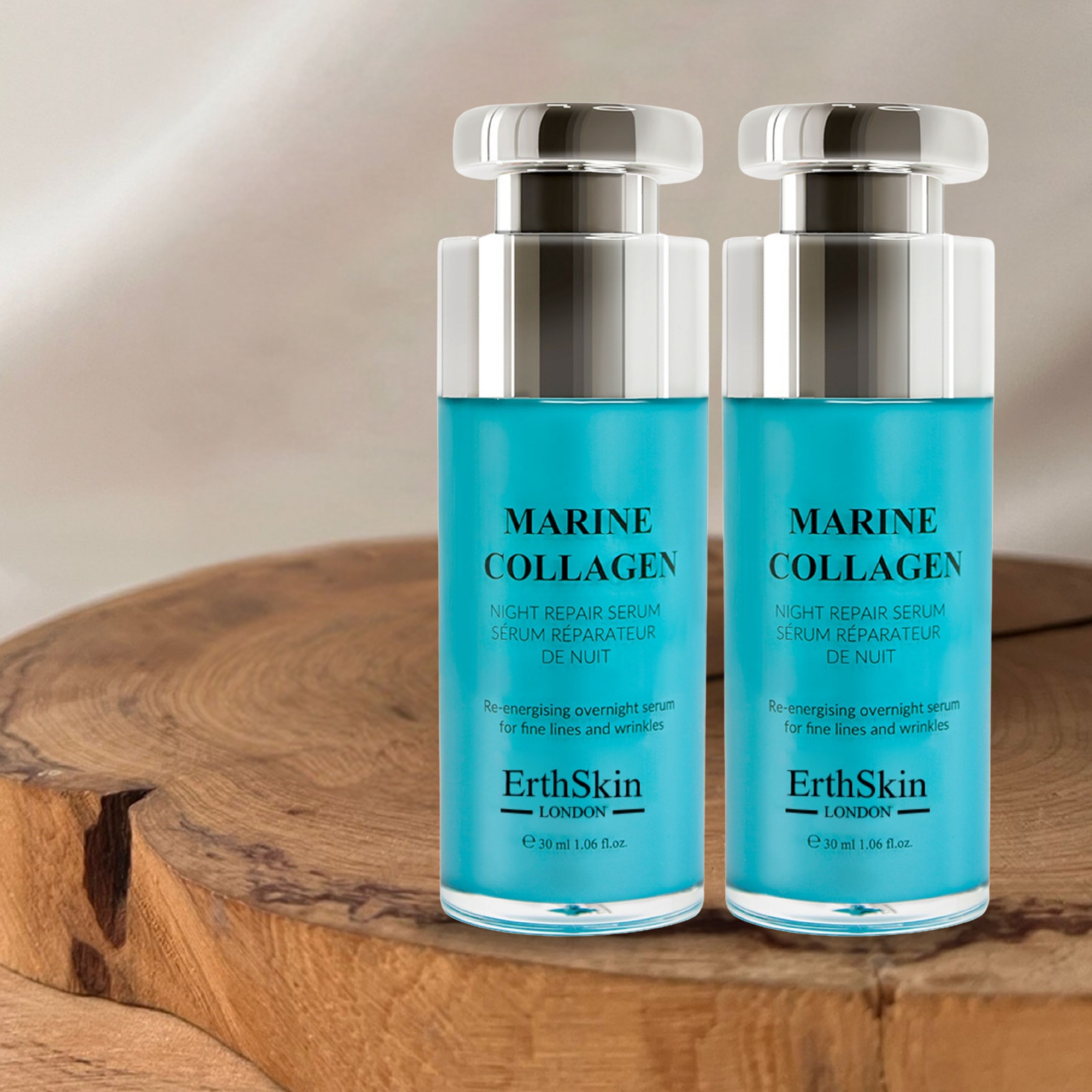 Deux flacons de sérum Marine Collagen sur bois. Flacons bleus avec bouchons argentés. Texte: ErthSkin London.