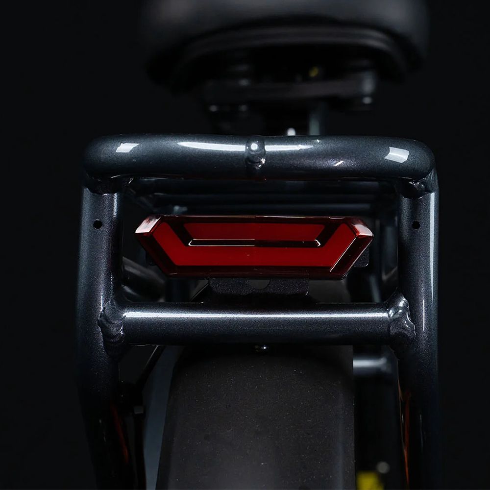 Achterlicht van een e-bike, rood en rechthoekig, bevestigd op de bagagedrager.