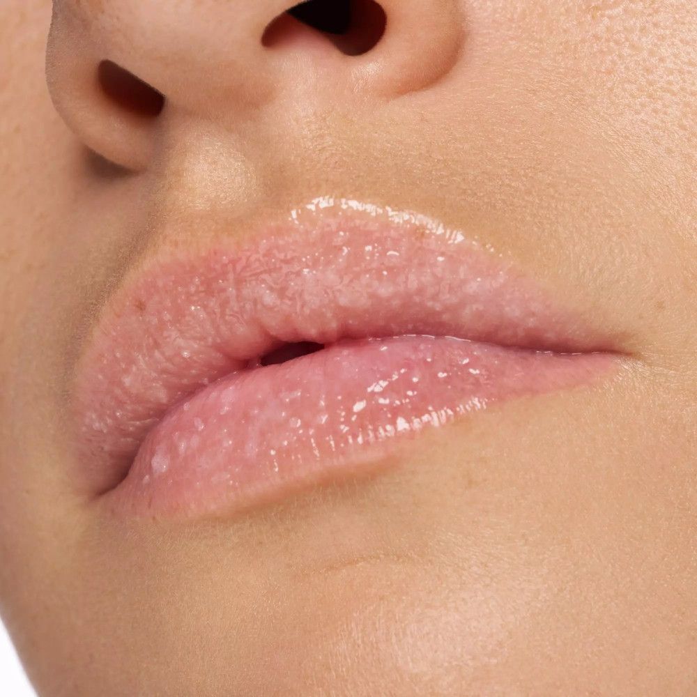 Gros plan sur les lèvres. Lèvres brillantes avec des particules exfoliantes visibles.