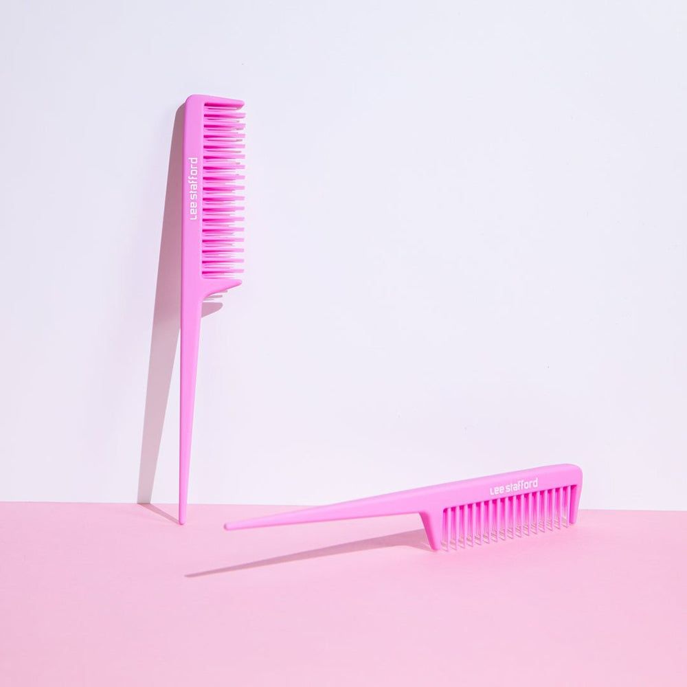 Deux peignes roses à dents fines et queues pointues, l'un debout, l'autre posé à plat.