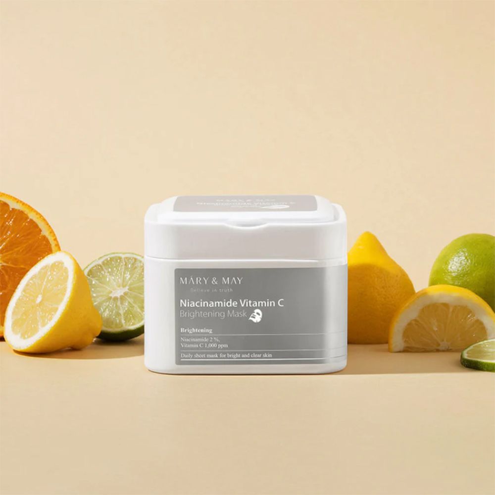 Witte container met MARY & MAY Niacinamide Vitamin C Brightening Mask. Citrusvruchten rond de container.