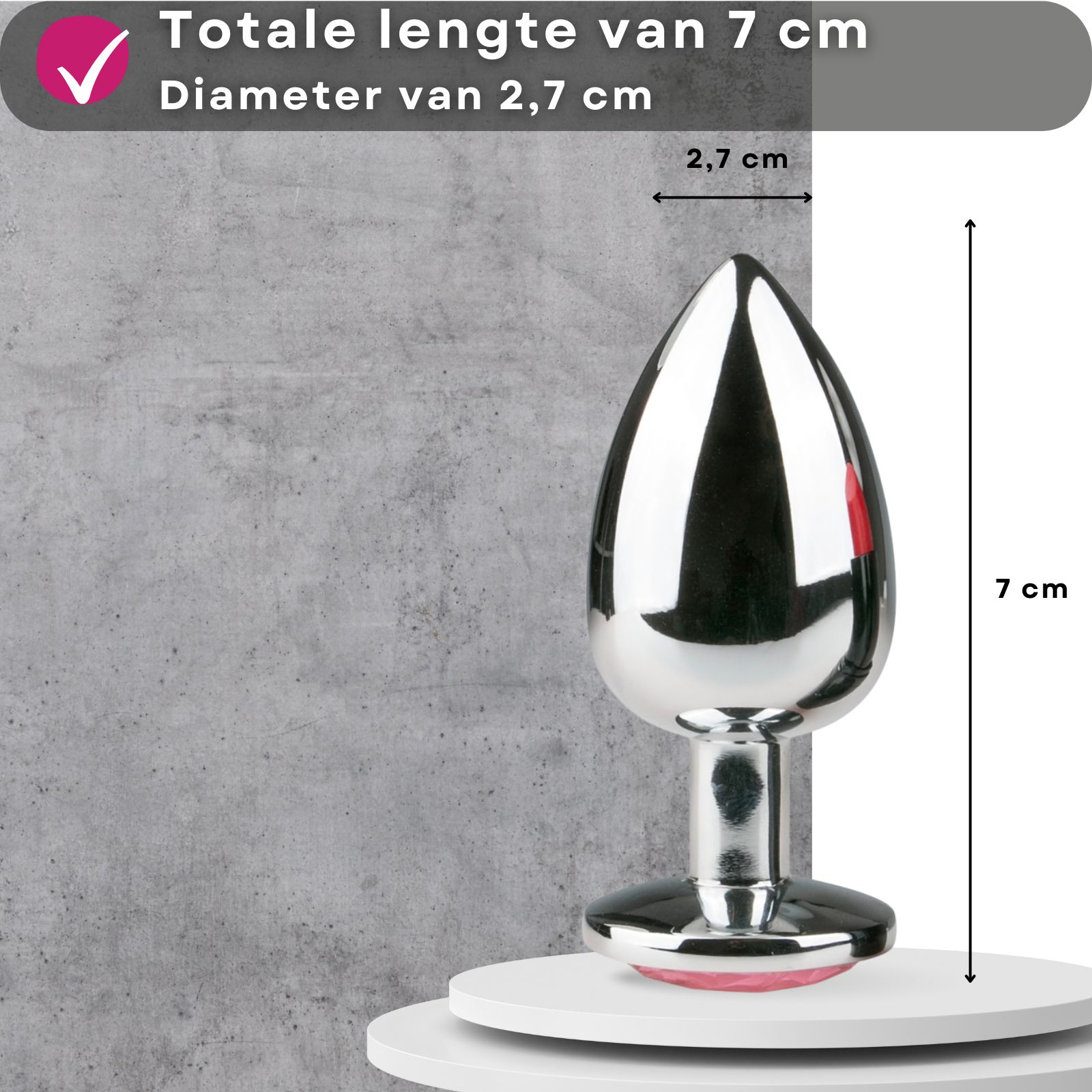 Metalen anale plug. Totale lengte 7 cm, diameter 2,7 cm. Op sokkel. Grijze achtergrond.