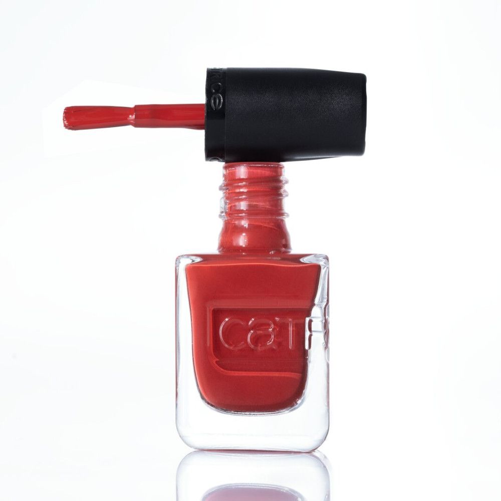 Vernis à ongles rouge dans un flacon transparent avec un bouchon noir et un pinceau.