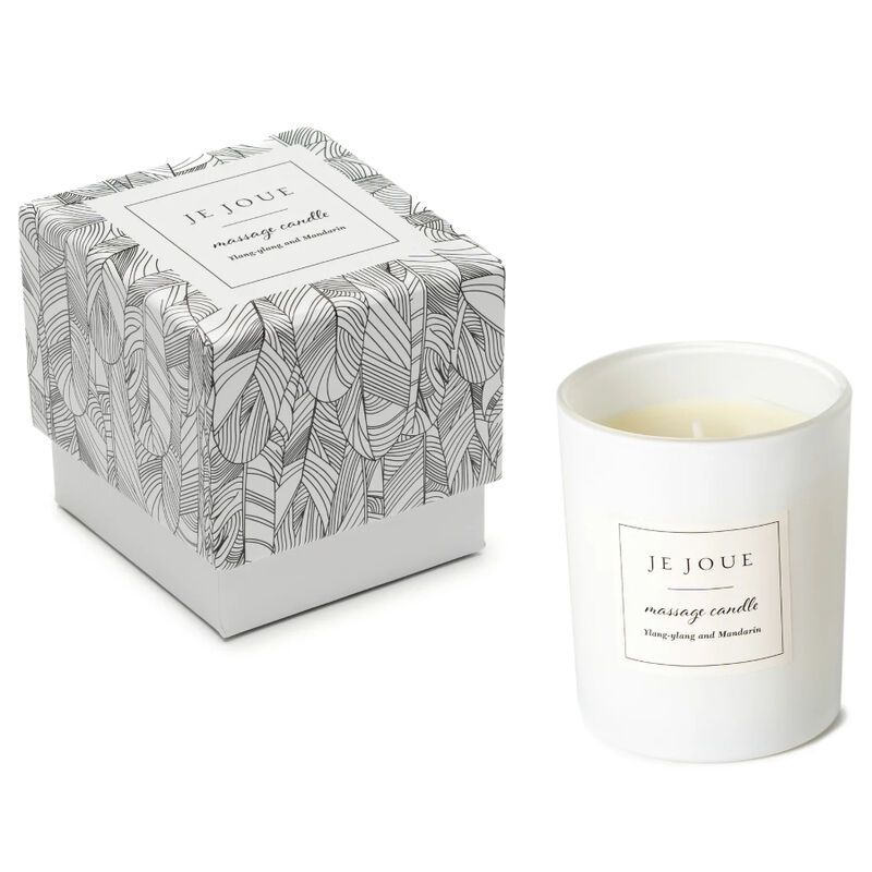 Bougie blanche cylindrique et boîte à motifs plumes. Étiquette: Je Joue, massage candle. Ingrédients: Ylang Ylang et Mandarine.