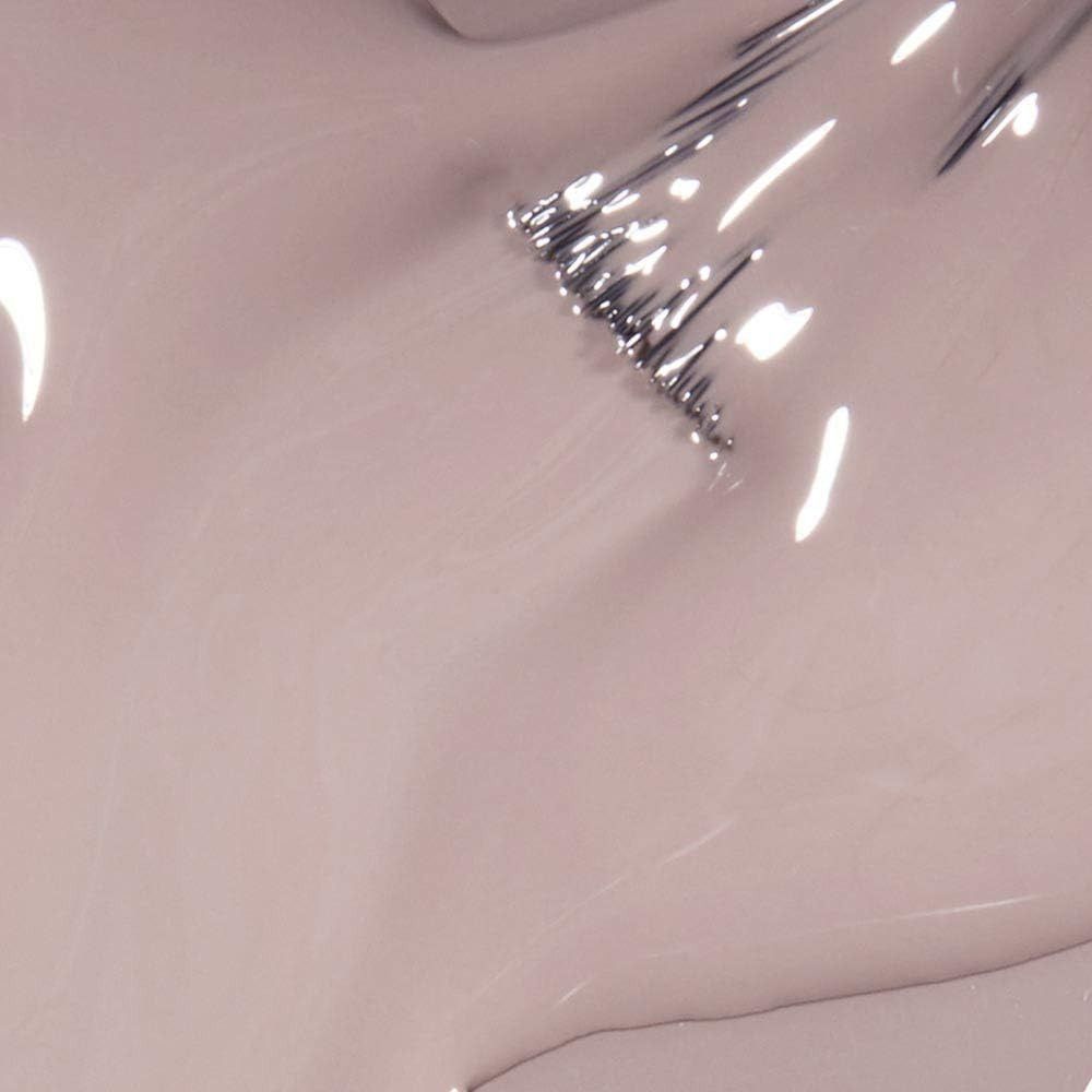 Gros plan sur du vernis à ongles brillant rose clair. La surface réfléchit la lumière.