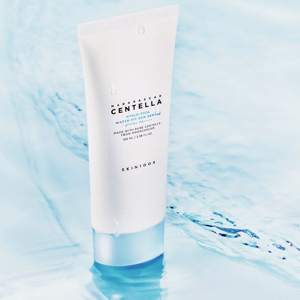 Witte tube in water. Opschrift: MADAGASCAR CENTELLA HYALU-CICA WATER-FIT SUN SERUM. Merk SKIN1004.